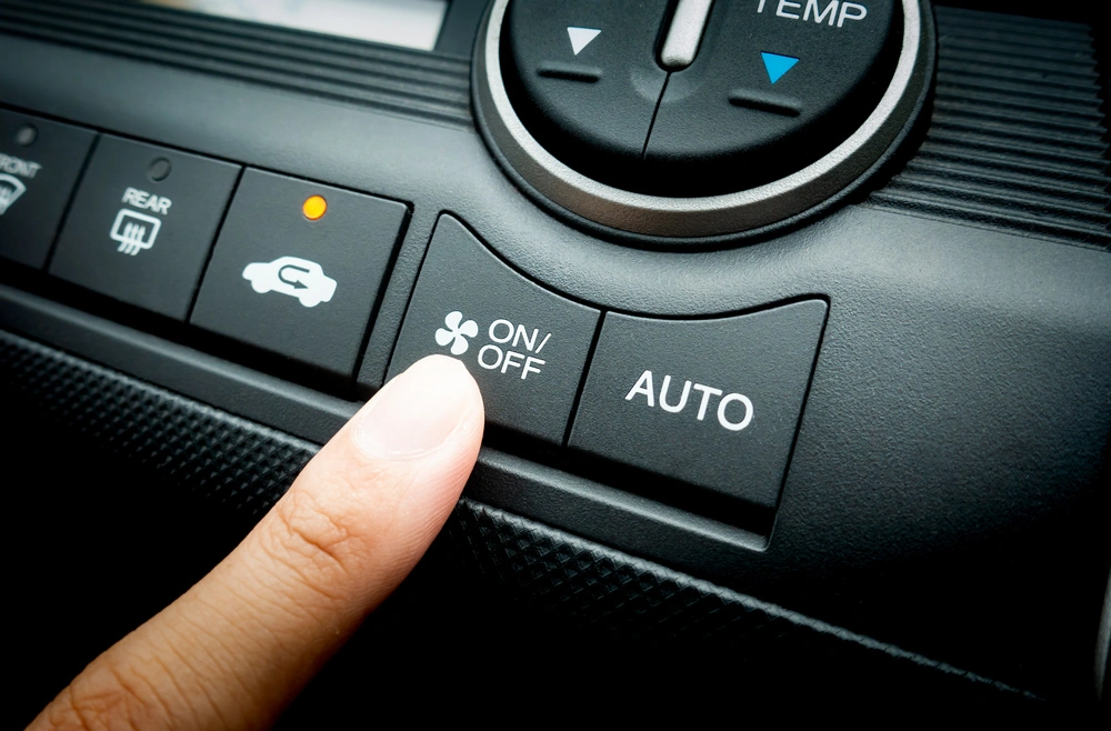 Finger pressing on Power button on off switch of a Car air conditioning and heating system To turn on the Fan of the A/C inside the Car